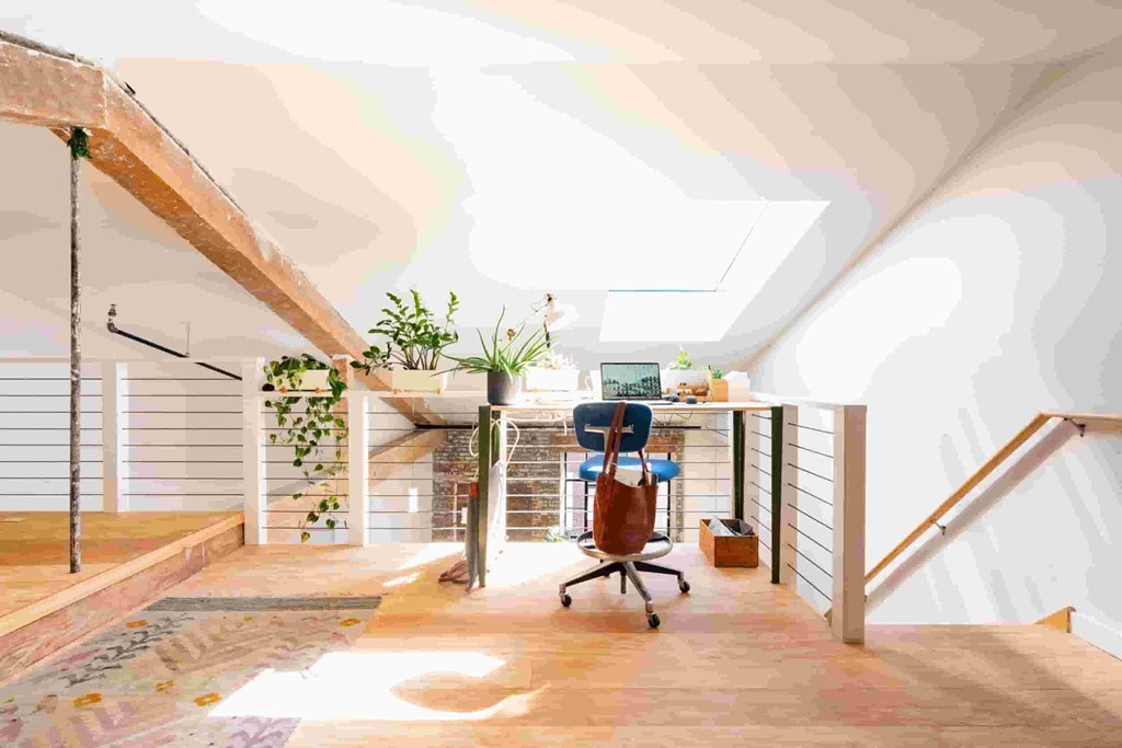 a home office with a desk and a chair in a room with a staircase
