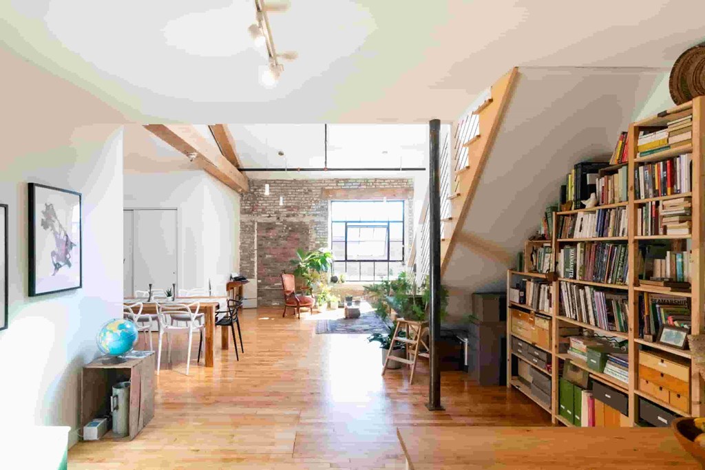 a large living room with a bookshelf full of books