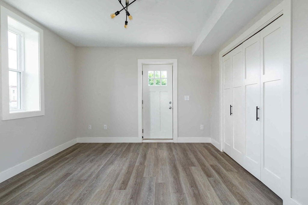 an empty room with white walls and a white door