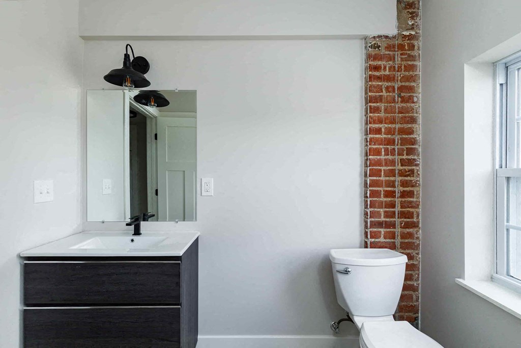 a bathroom with a toilet and a sink and a mirror