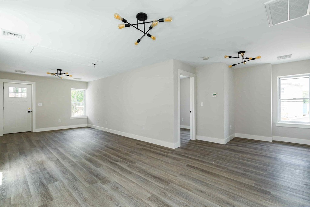 an empty living room with white walls and wood flooring