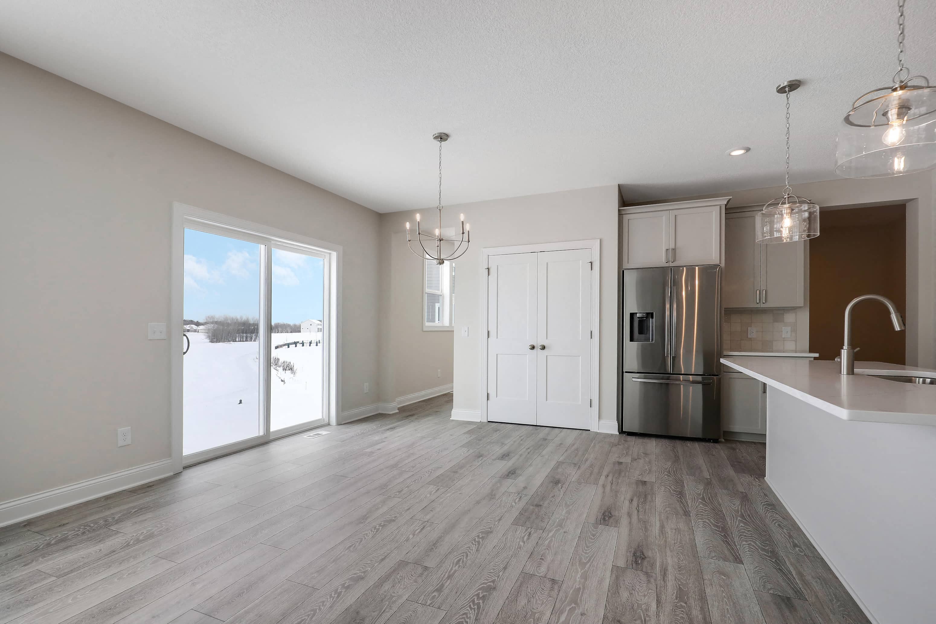 an open kitchen and living room with a stainless steel refrigerator