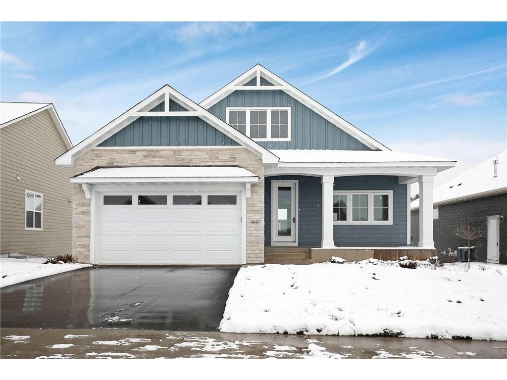 a house with a white garage door in the snow