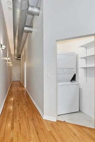 a hallway with a white refrigerator and a wood floor