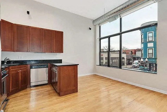 an empty kitchen with wooden cabinets and a large window