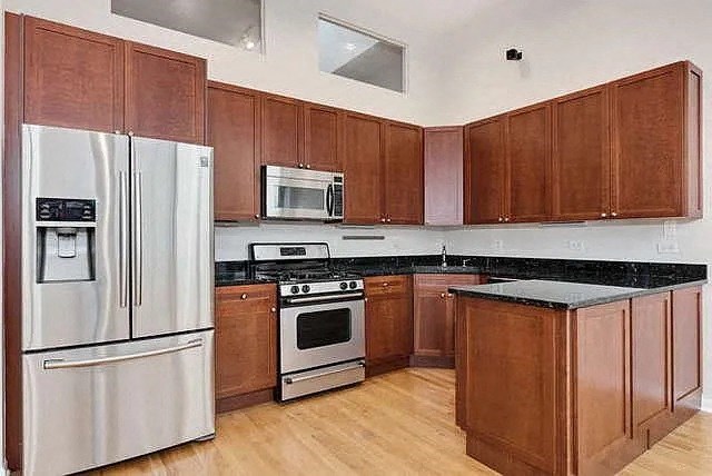 a kitchen with wooden cabinets and stainless steel appliances
