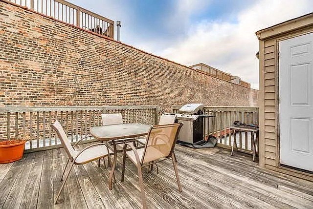 a patio with a table and chairs and a brick wall