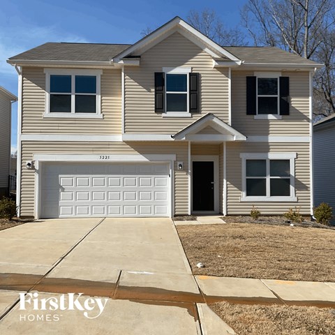 a tan house with a white garage door