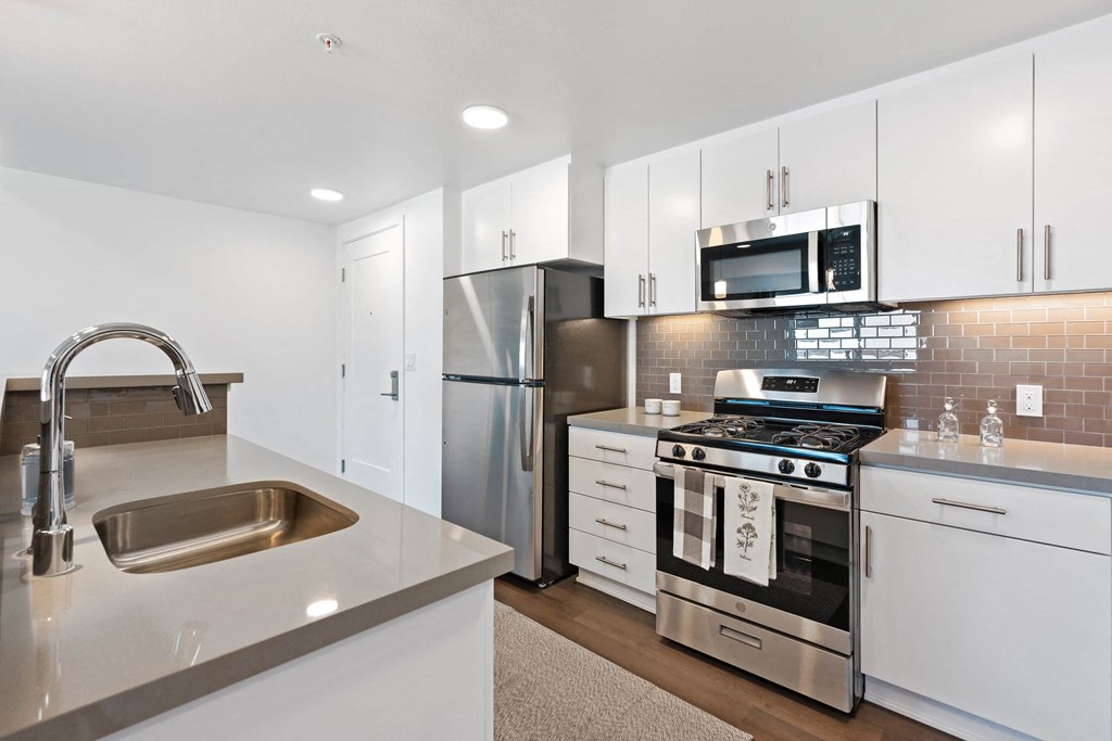 a kitchen with white cabinets and stainless steel appliances