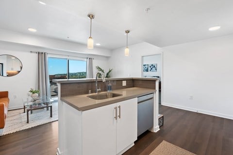 A modern kitchen with a large island and a view of the outdoors.