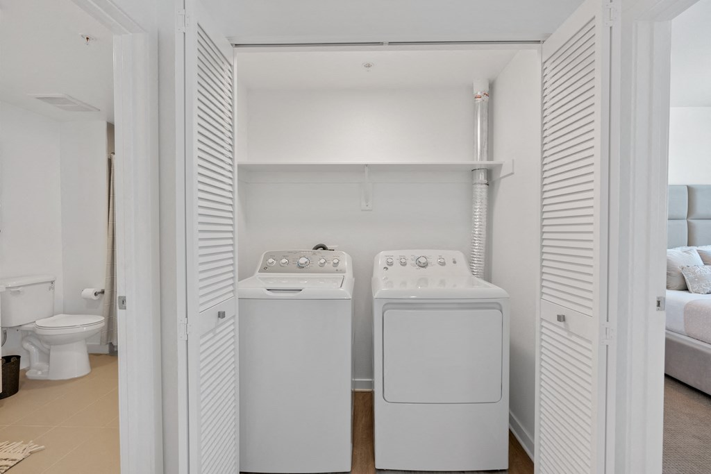 a laundry room with a washer and dryer and a toilet