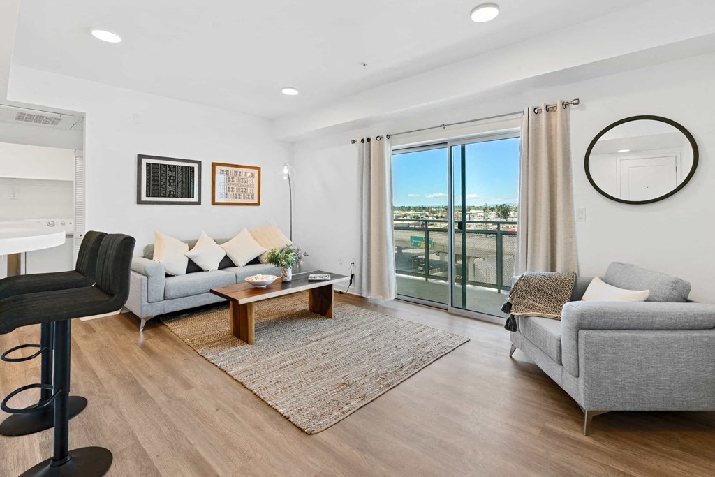 a living room with two couches and a table    and a balcony