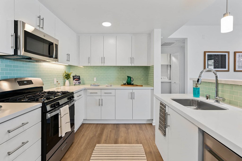 a kitchen with a sink and a stove and a microwave