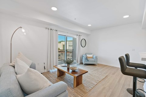 A living room with a grey couch, a wooden coffee table, and a chair.