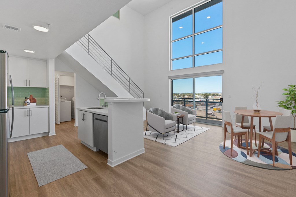 an open living room with a kitchen and a dining area with a table and chairs