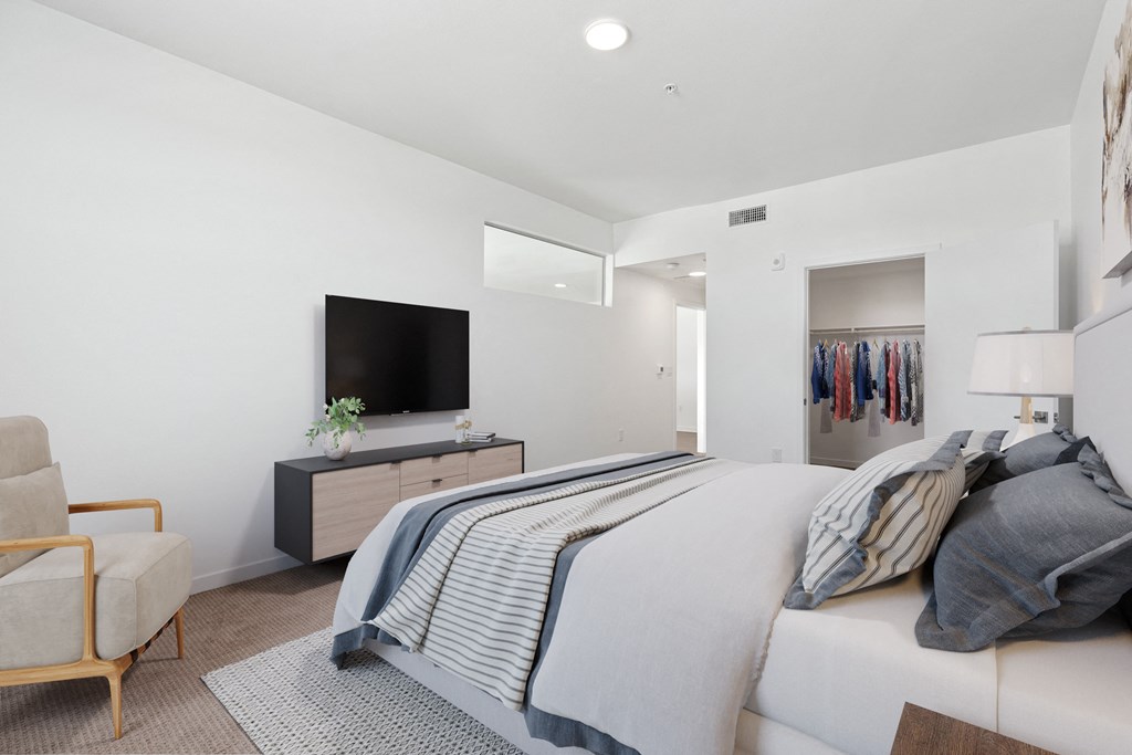 a bedroom with a large bed and a tv