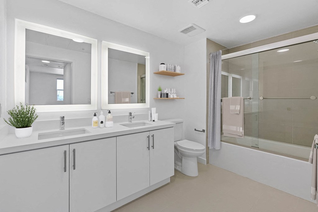 a white bathroom with two sinks and a shower
