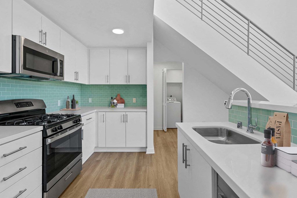 a kitchen with a sink and a stove and a microwave