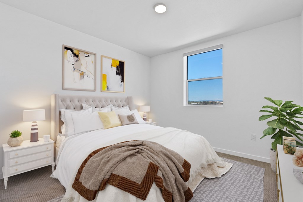 a white bedroom with a bed and a window