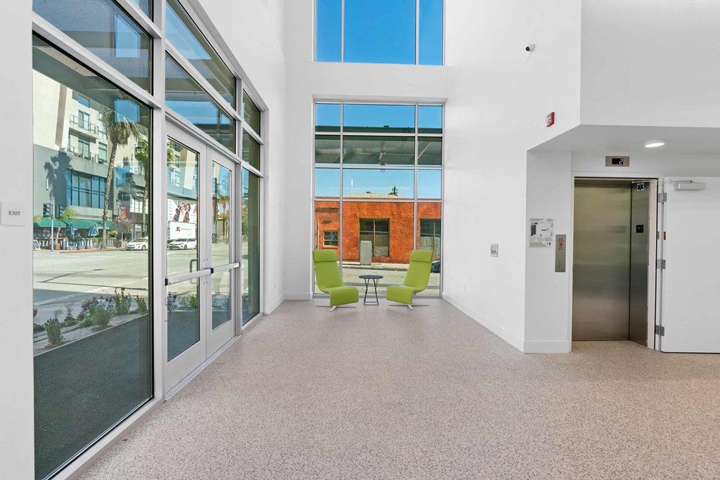 the lobby of a building with glass doors and a table with chairs