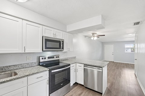 A kitchen with white cabinets and stainless steel appliances.