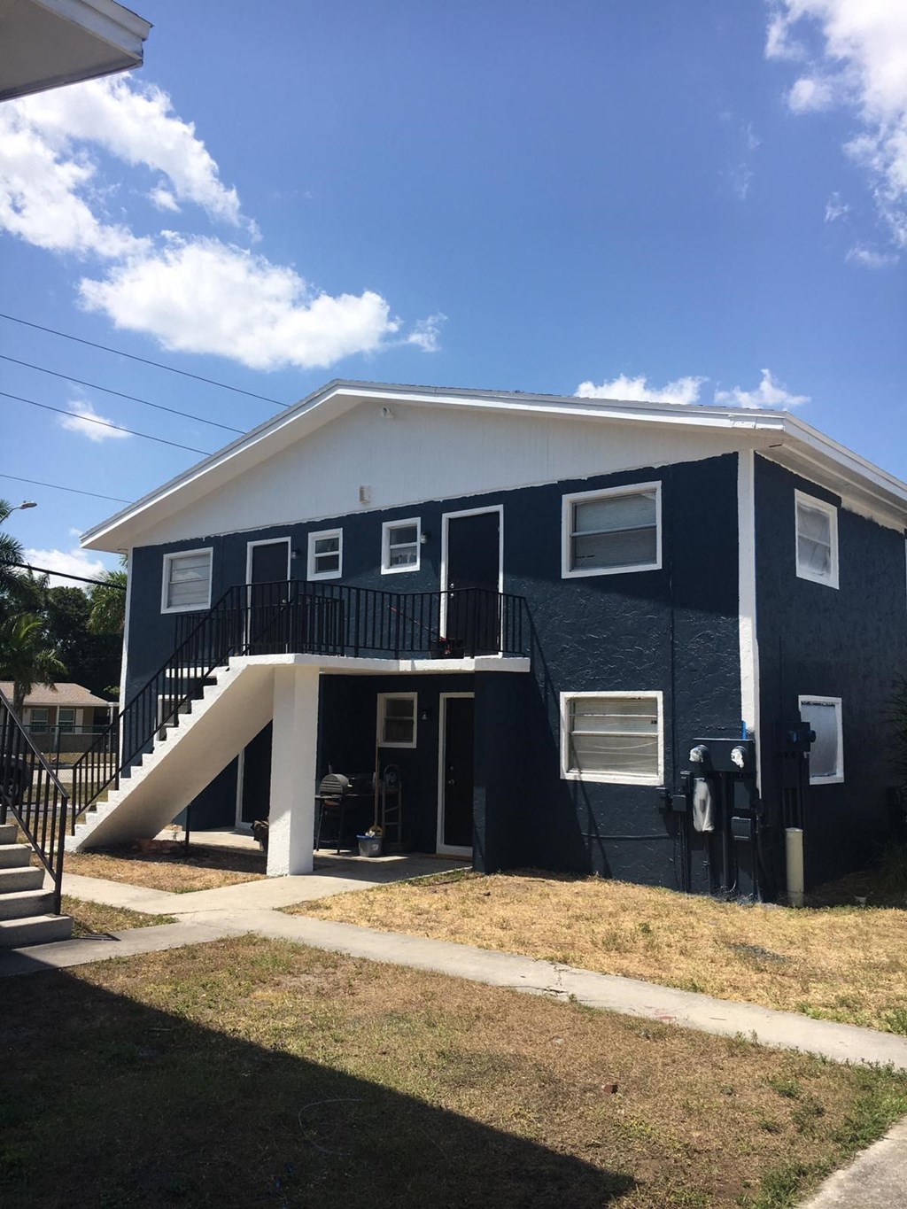 a blue house with a porch and a staircase