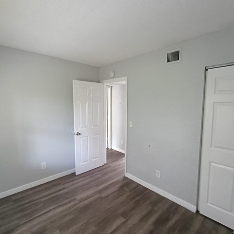 A room with a white door and a white wall.