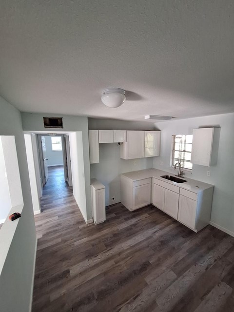 A kitchen with white cabinets and a sink.