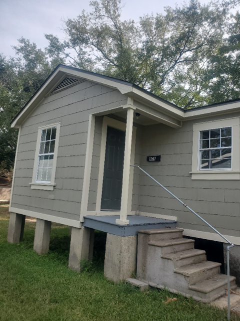 the front of a house with stairs and a blue front door