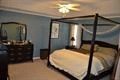 a bedroom with a bed and a dresser and a ceiling fan