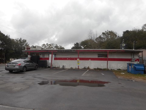 an old building with a parking lot and a car