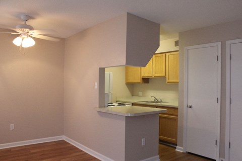 A kitchen with a white counter top and wooden cabinets.