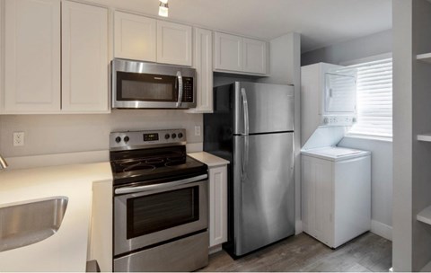 A kitchen with white cabinets and stainless steel appliances.