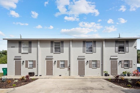A row of identical houses with brown doors and windows.