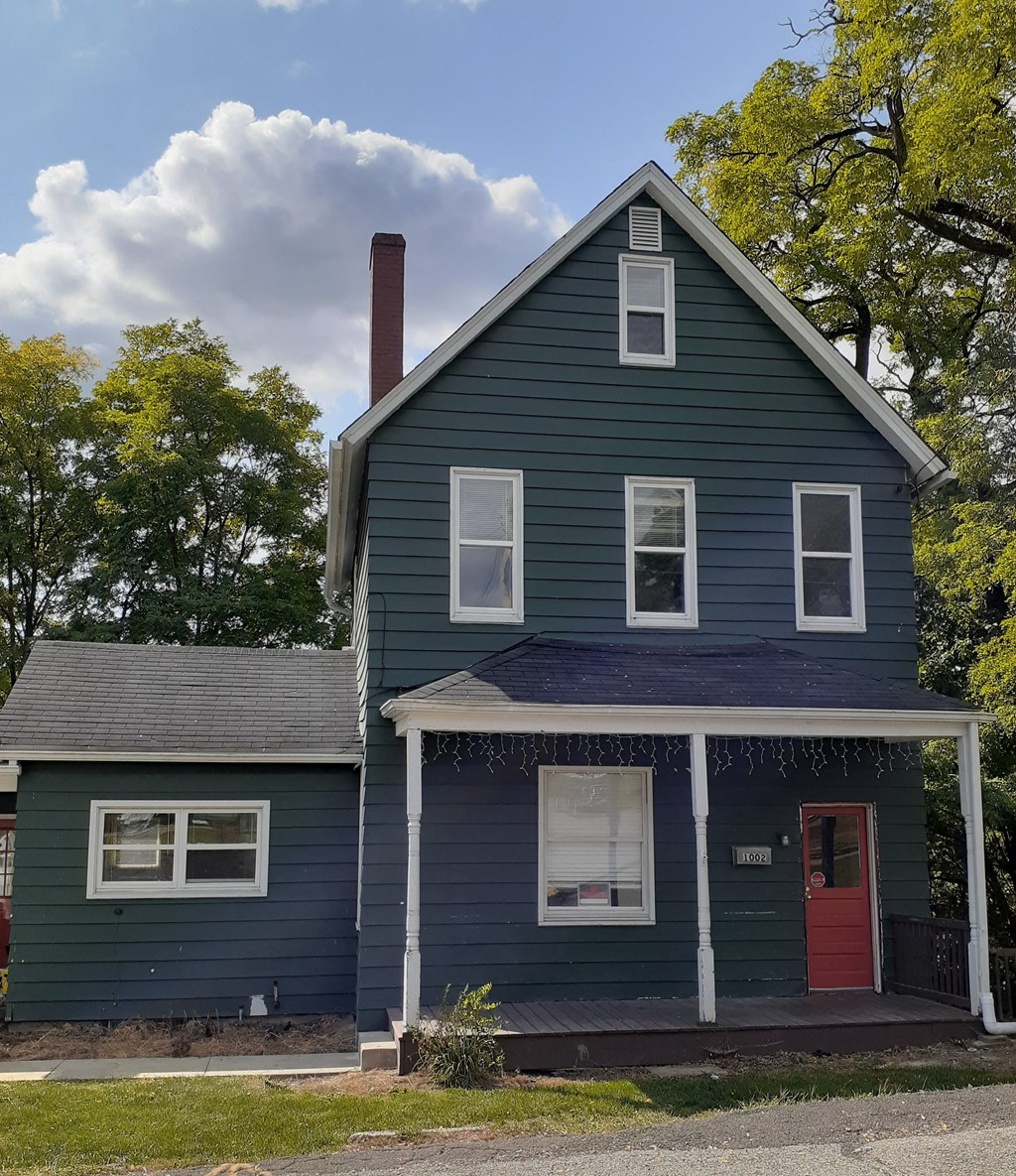 the front of a blue house with a red door