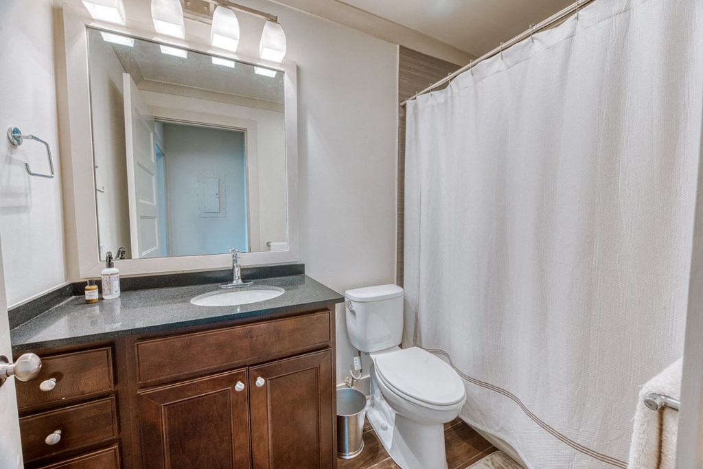 a bathroom with a shower and a sink and a toilet