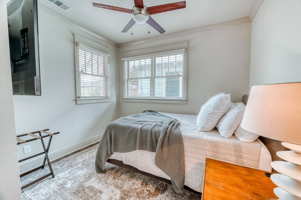 a bedroom with a bed and a ceiling fan