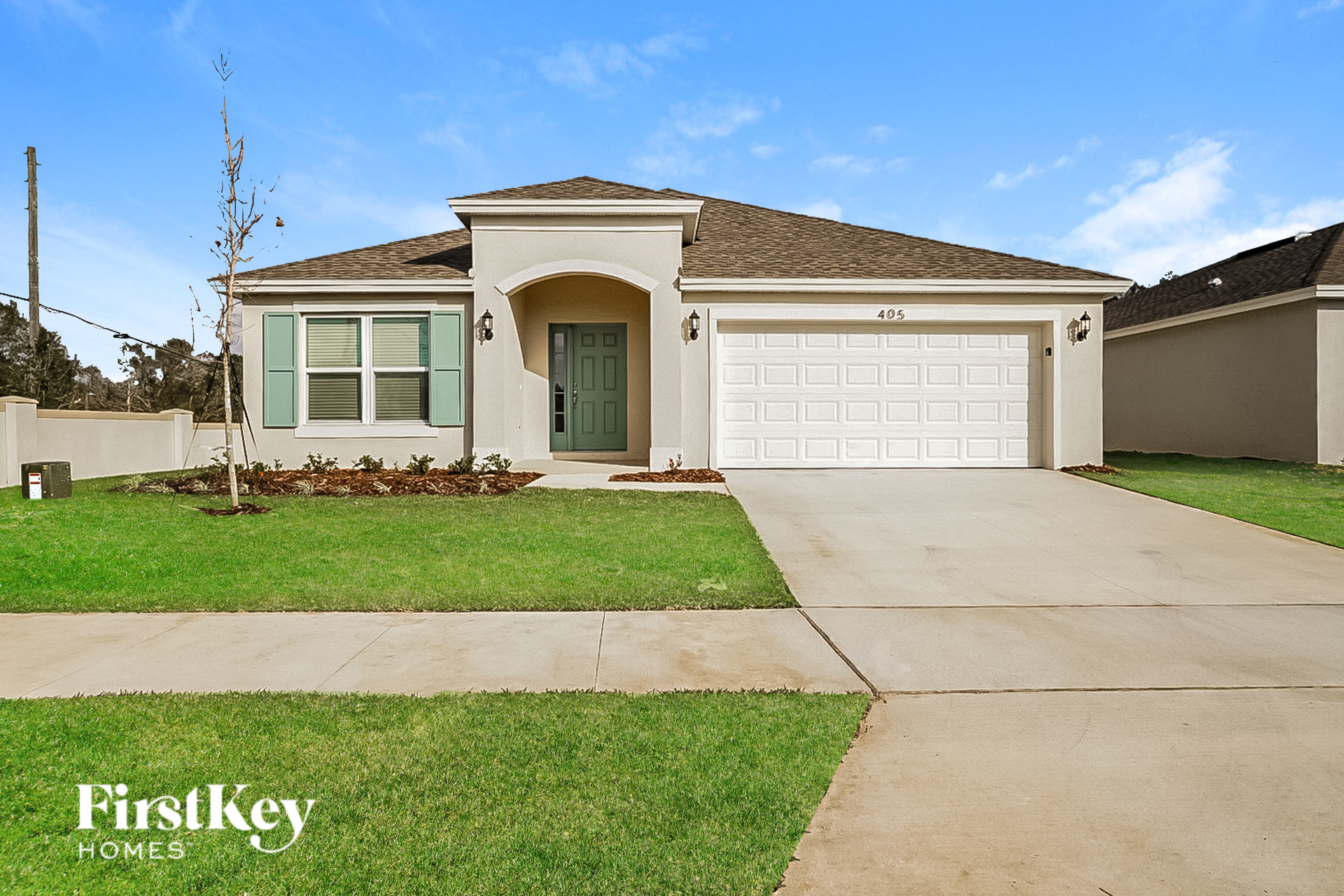 A house with a green door and a garage door is for sale.