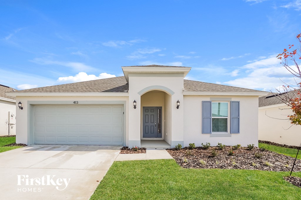 a white house with a blue door and a lawn
