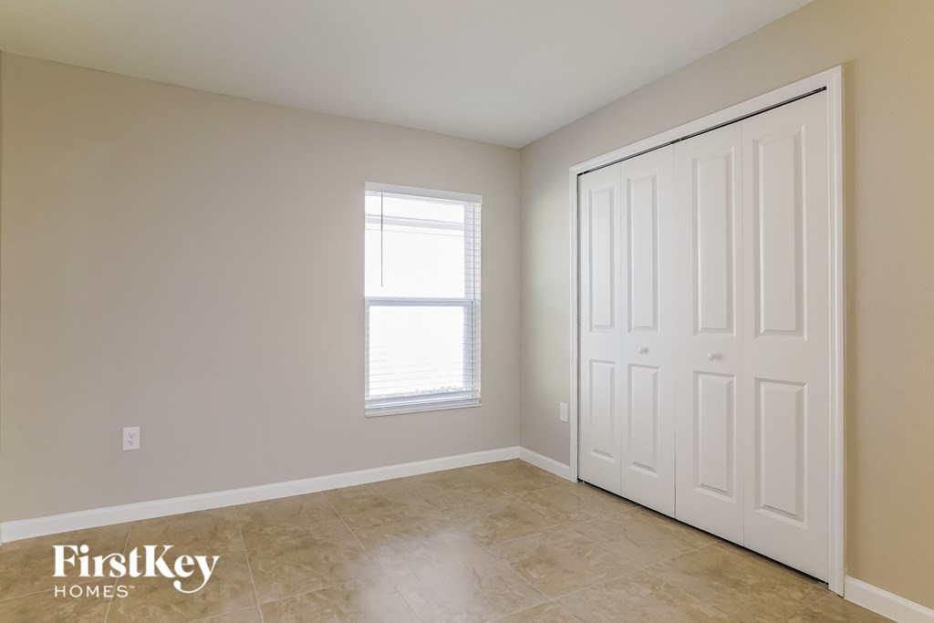an empty room with a white door and a window