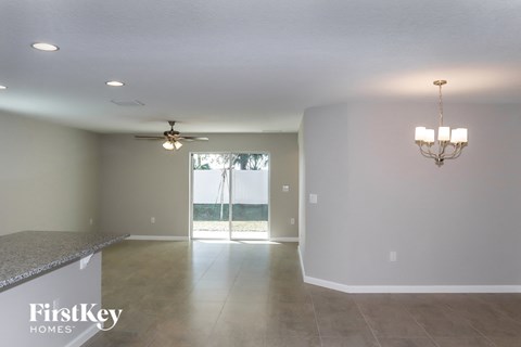 A spacious room with a ceiling fan and a chandelier.