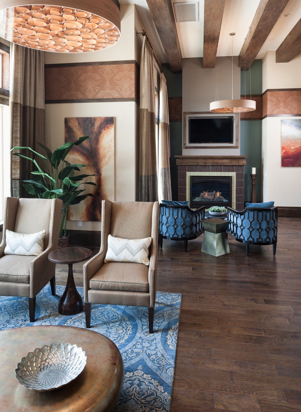 a clubhouse room with chairs and a table and a fireplace