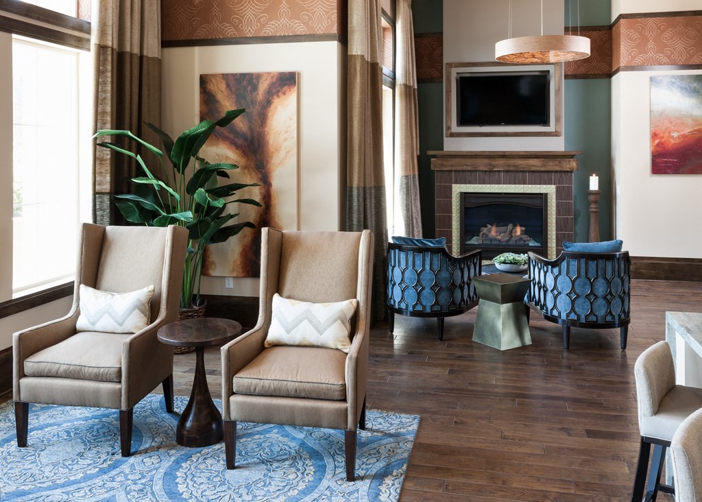 a living room with chairs and a fireplace