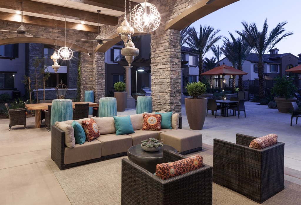 a patio with couches and tables in a courtyard