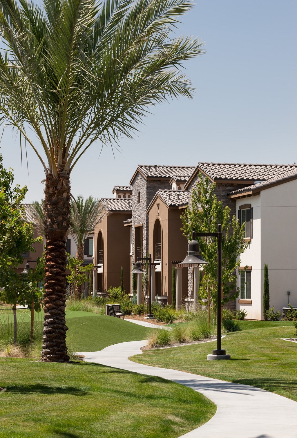 a group of apartment buildings with palm trees in front of them