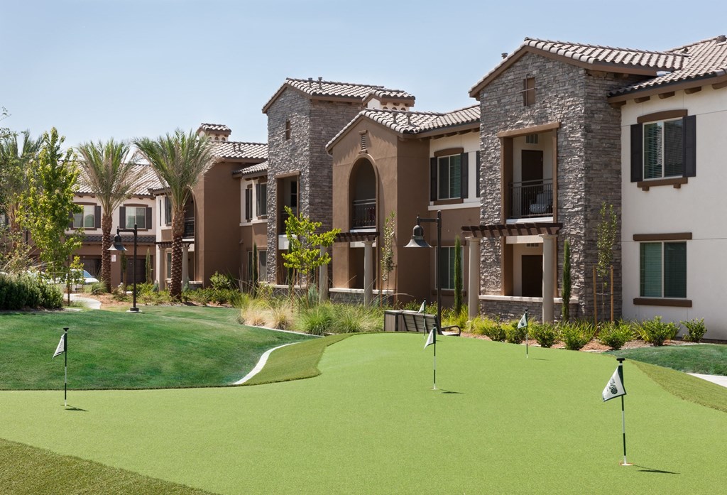 a putting green with apartments in the background