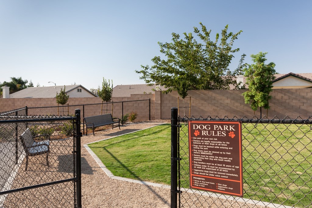 a dog park and rules sign on a chain link fence