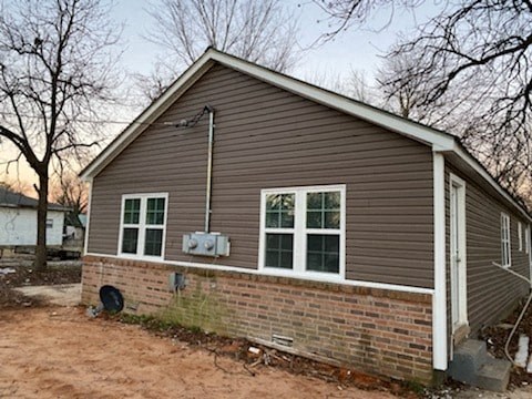 A small house with a brown siding and a white door.