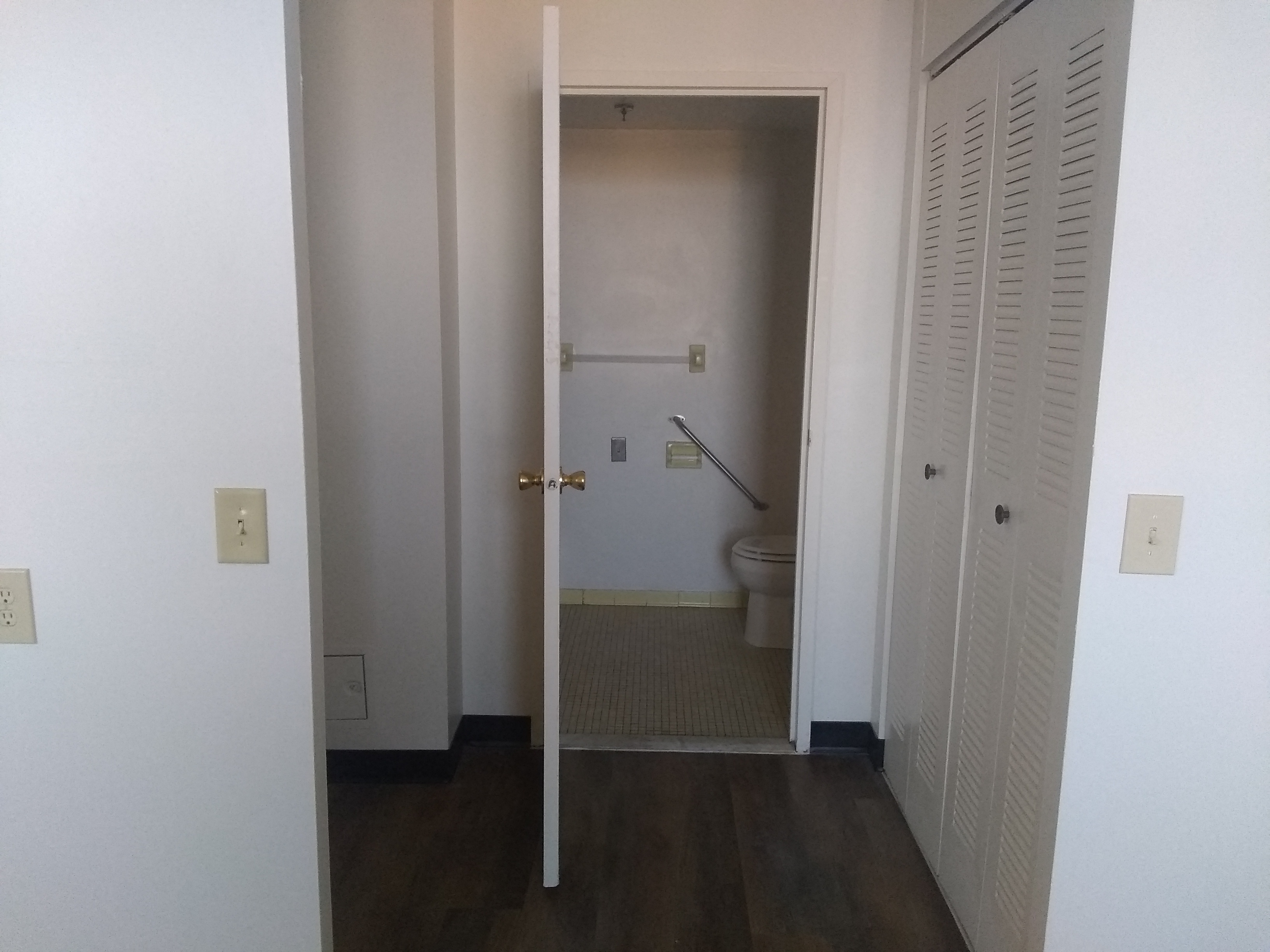 A white door is open to a small bathroom.