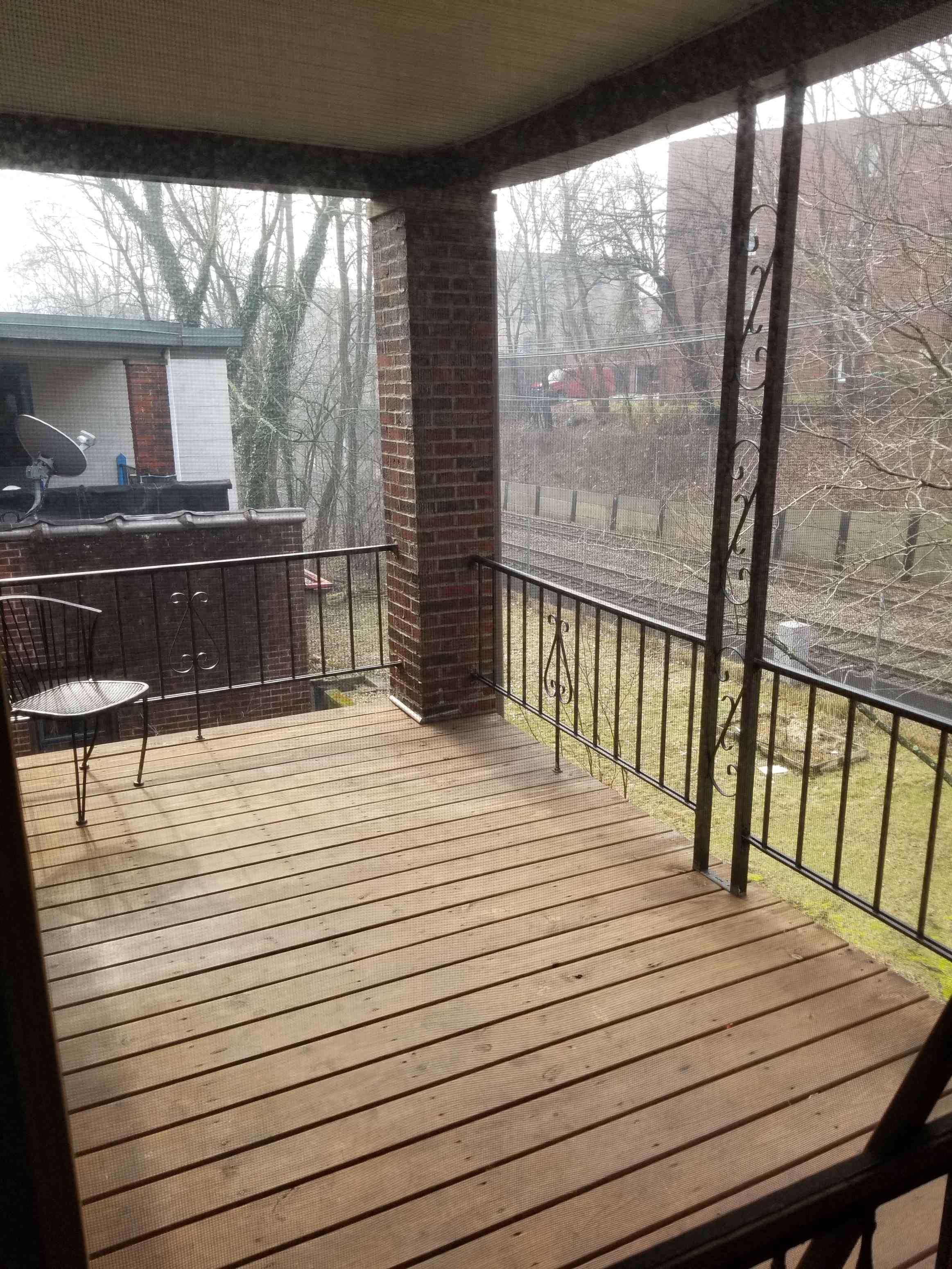 a screened in porch with a view of a train